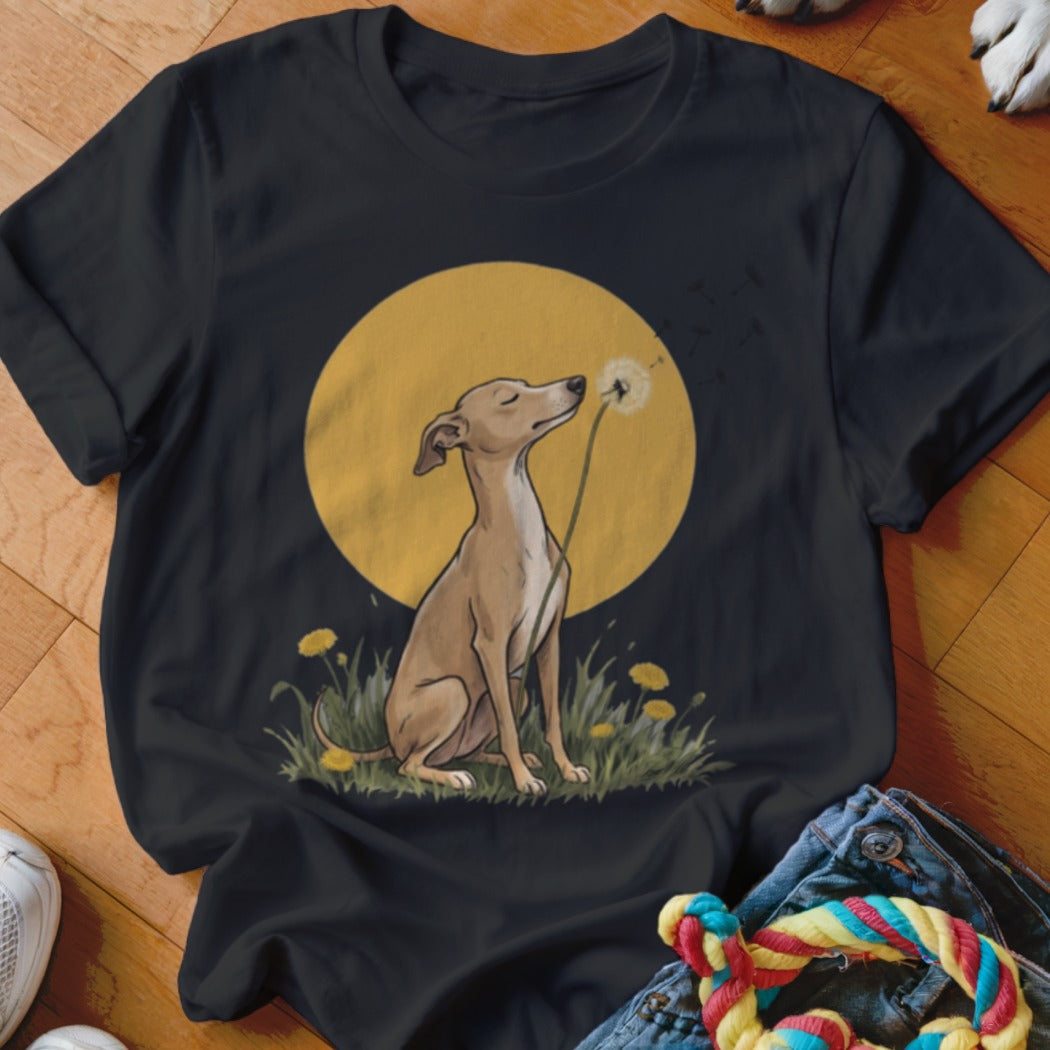 Black t-shirt featuring an illustration of a fawn-colored dog blowing dandelion seeds against a yellow moon.