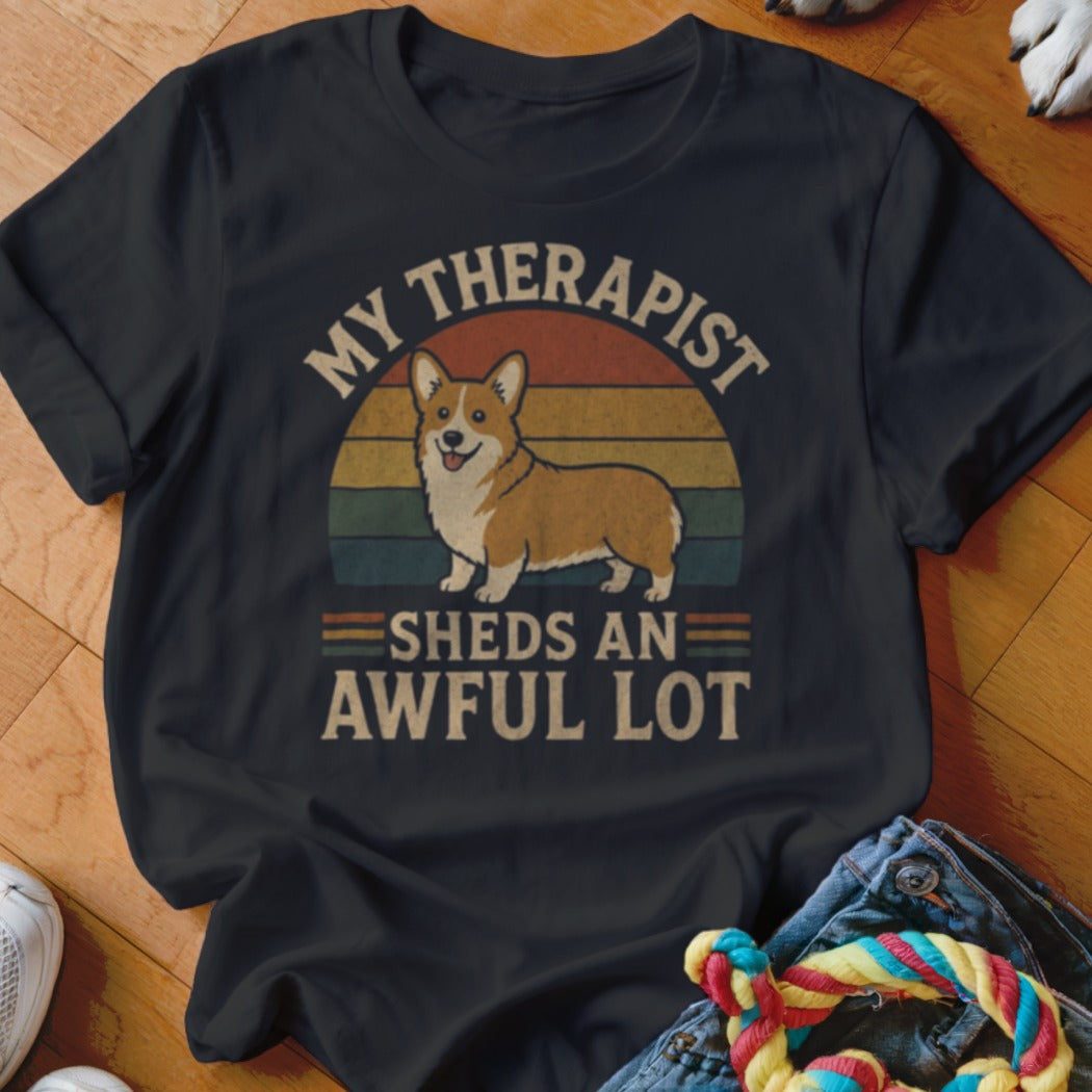Black t-shirt with a corgi illustration and text: "MY THERAPIST SHEDS AN AWFUL LOT."