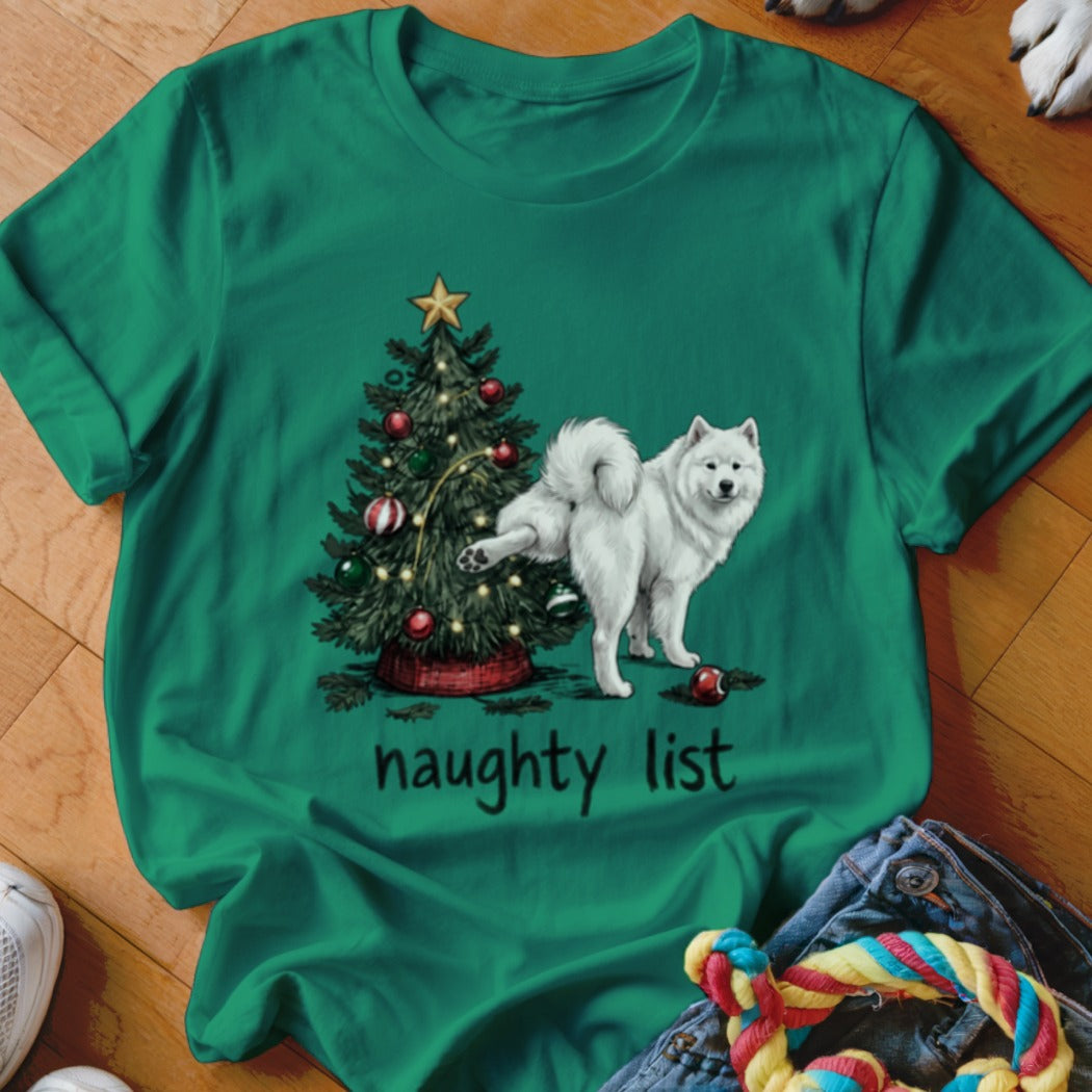 Green t-shirt featuring a graphic of a white dog peeing on a Christmas tree with text reading naughty list.