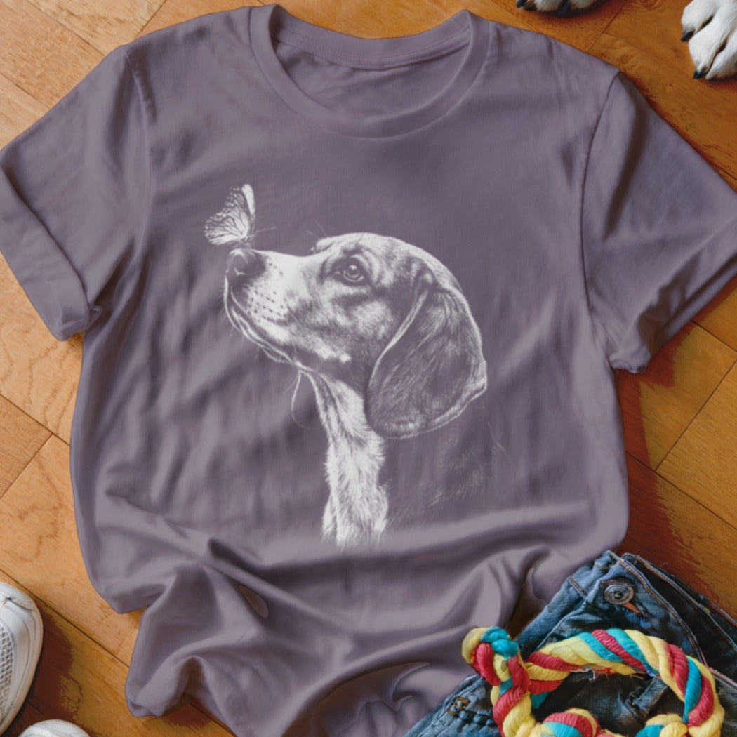 A gray short-sleeve t-shirt printed with a white sketch of a dog looking at a butterfly on its nose.