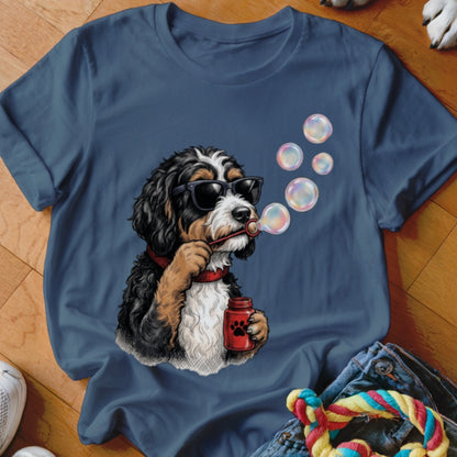 A blue crewneck t-shirt featuring a graphic of a black and white dog blowing bubbles.