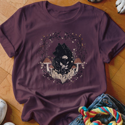 Plum-colored t-shirt featuring a graphic of a black dog surrounded by mushrooms and foliage.