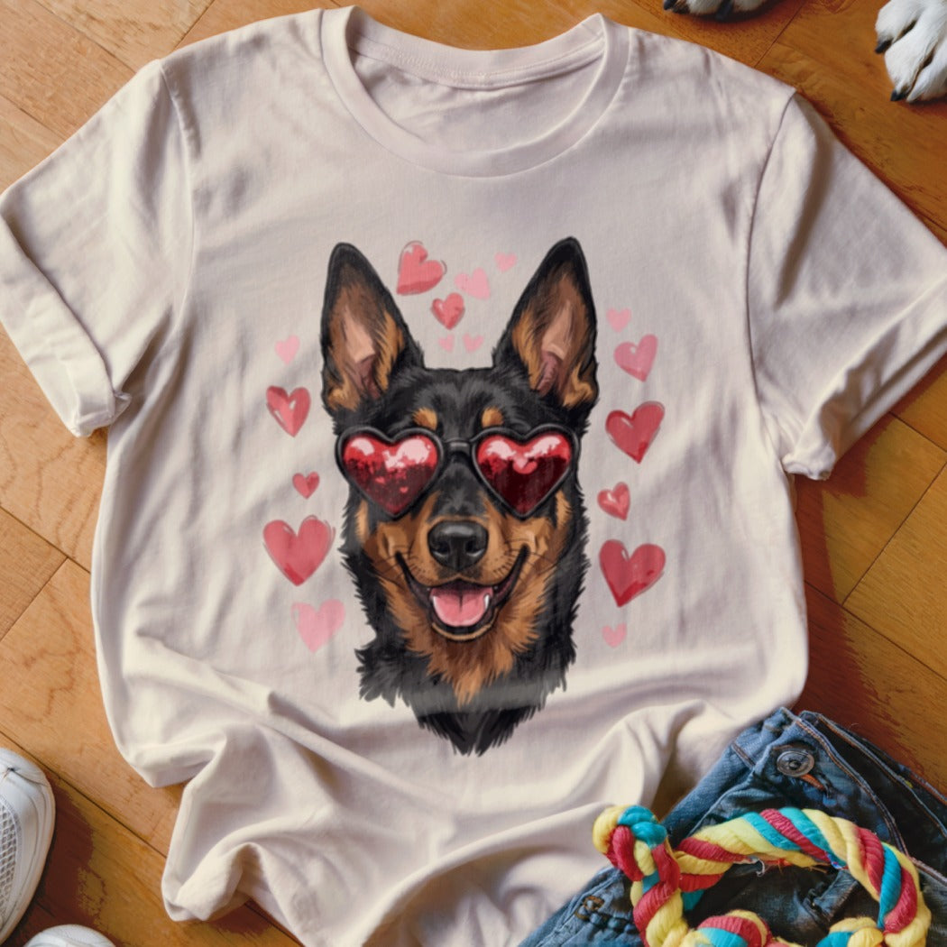 A light beige t-shirt featuring a graphic of a black and tan dog wearing heart-shaped sunglasses, surrounded by pink hearts.