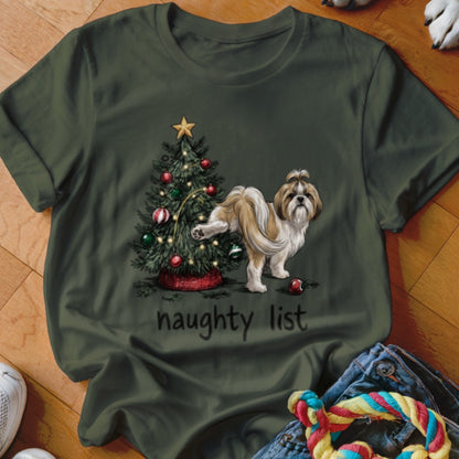 An olive green t-shirt featuring an illustration of a dog peeing on a Christmas tree above the text "naughty list".