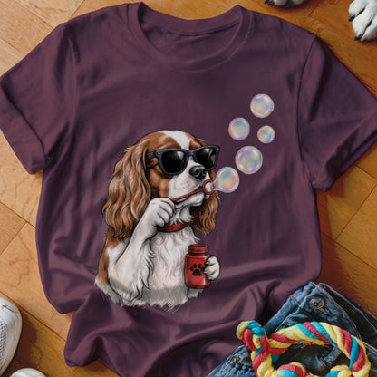 Maroon t-shirt featuring a graphic of a Cavalier King Charles Spaniel wearing sunglasses and blowing soap bubbles.