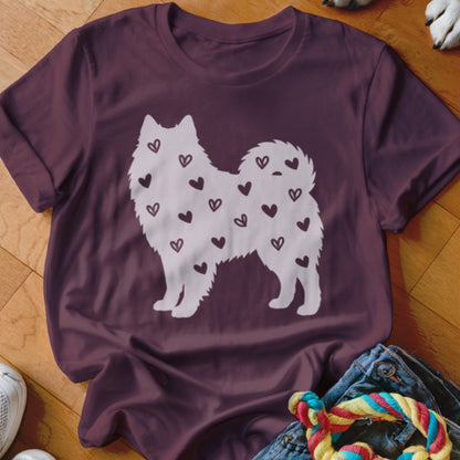 White dog silhouette covered in small hearts on a maroon t-shirt.