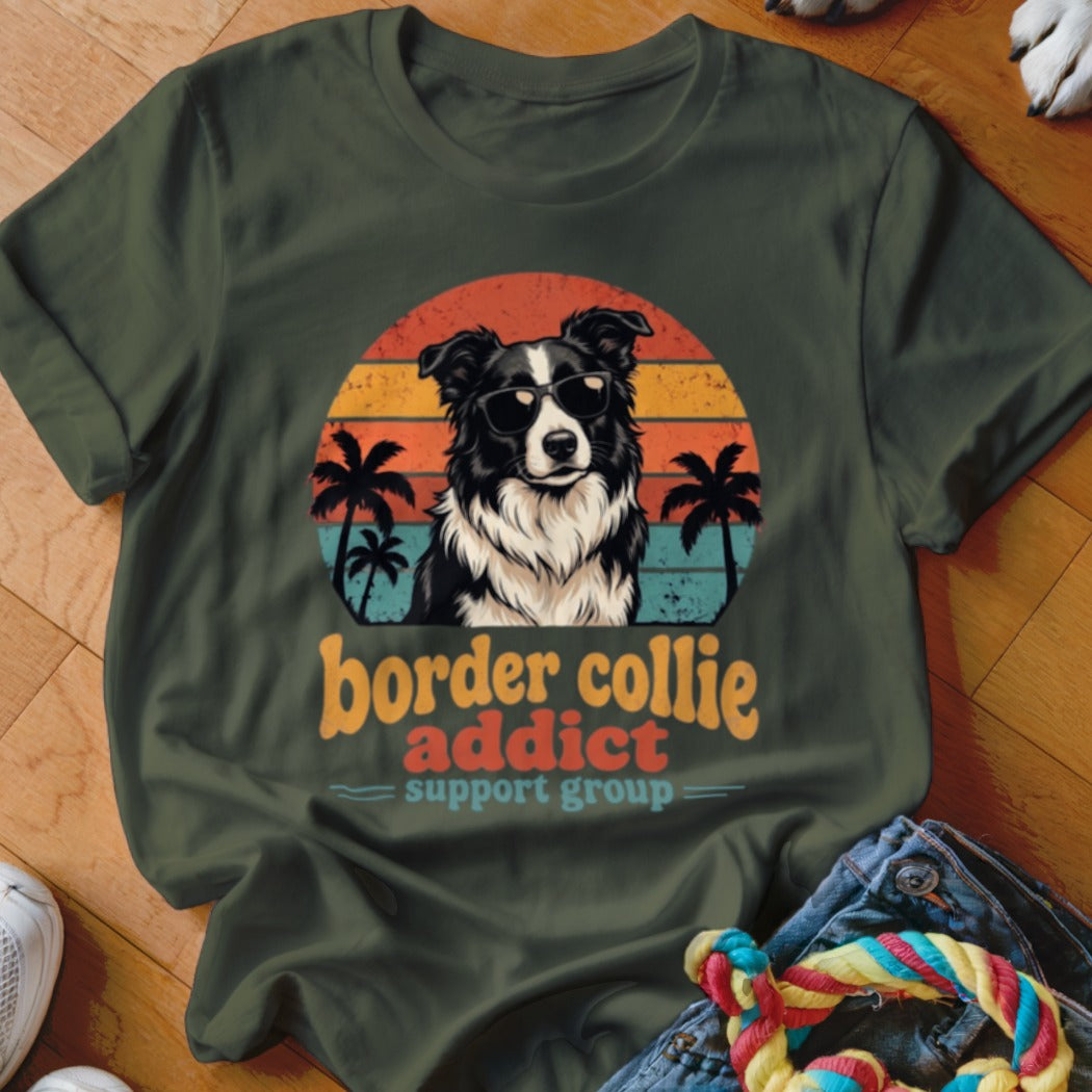 Dark green crewneck t-shirt featuring a retro sunset graphic, wearing sunglasses, and text reading Border Collie Addict Support Group.