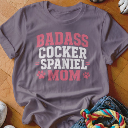 Gray t-shirt with pink and white text that reads "BADASS COCKER SPANIEL MOM."