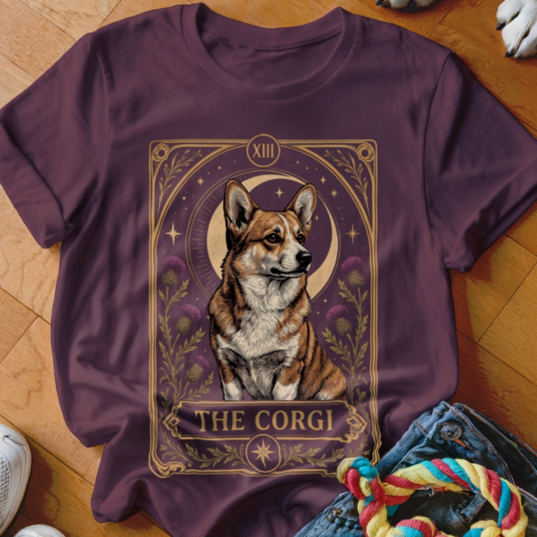 Purple t-shirt featuring a tarot card graphic of a corgi against a moon and thistle background.
