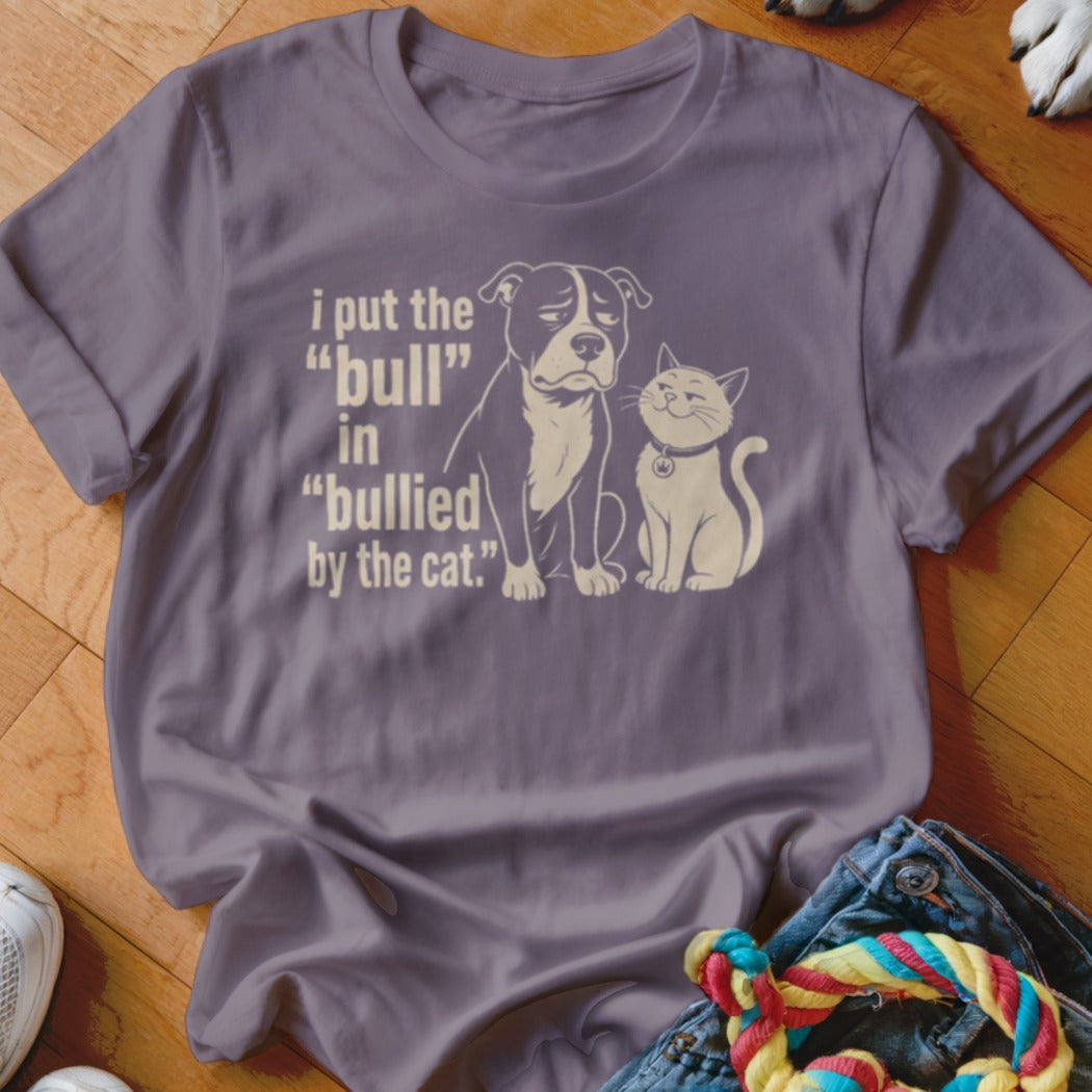 Purple t-shirt with a distressed print of a sad pit bull and a smug cat. Text reads "i put the "bull" in "bullied by the cat.""