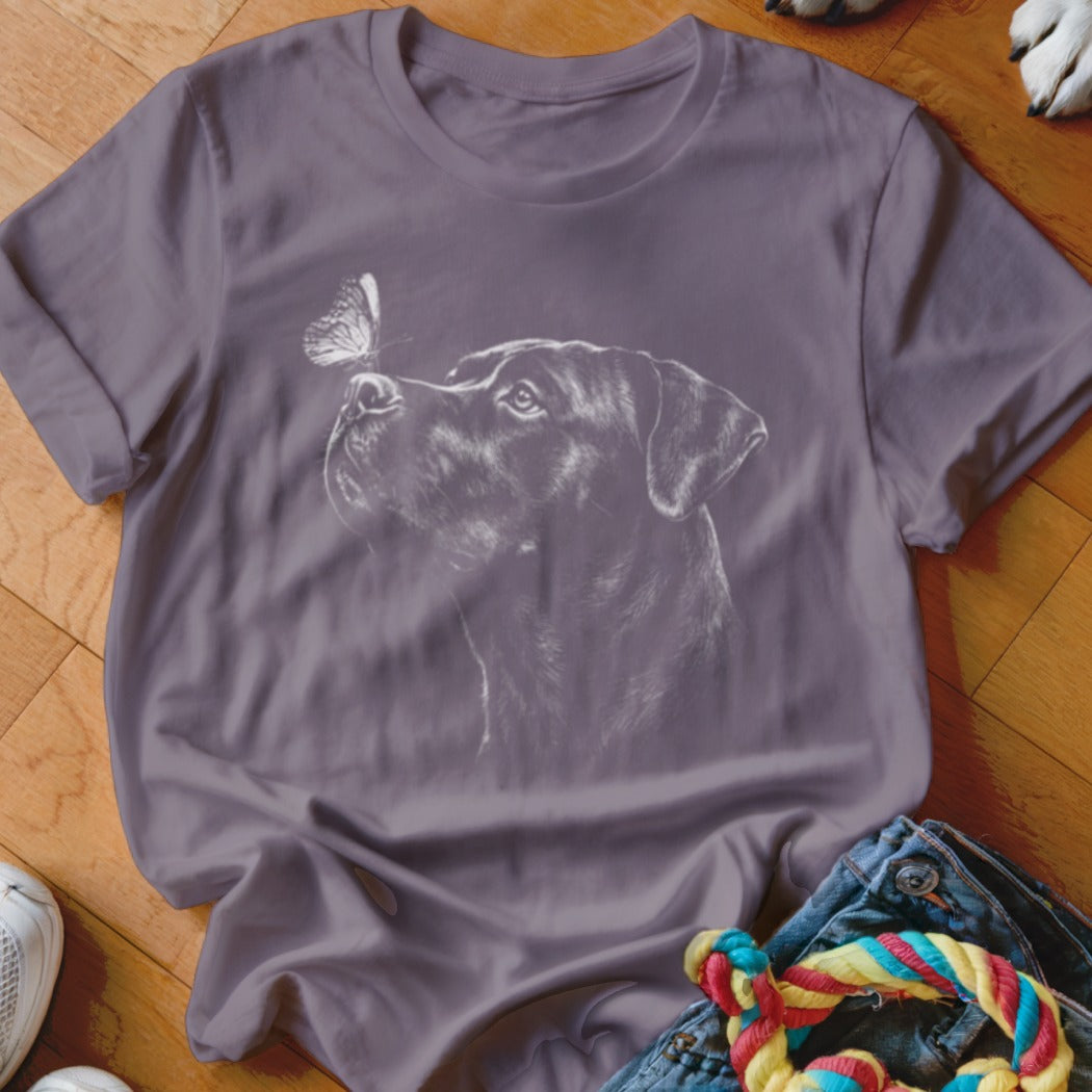 Slate purple short-sleeve t-shirt featuring a white line art graphic of a dog looking at a butterfly.