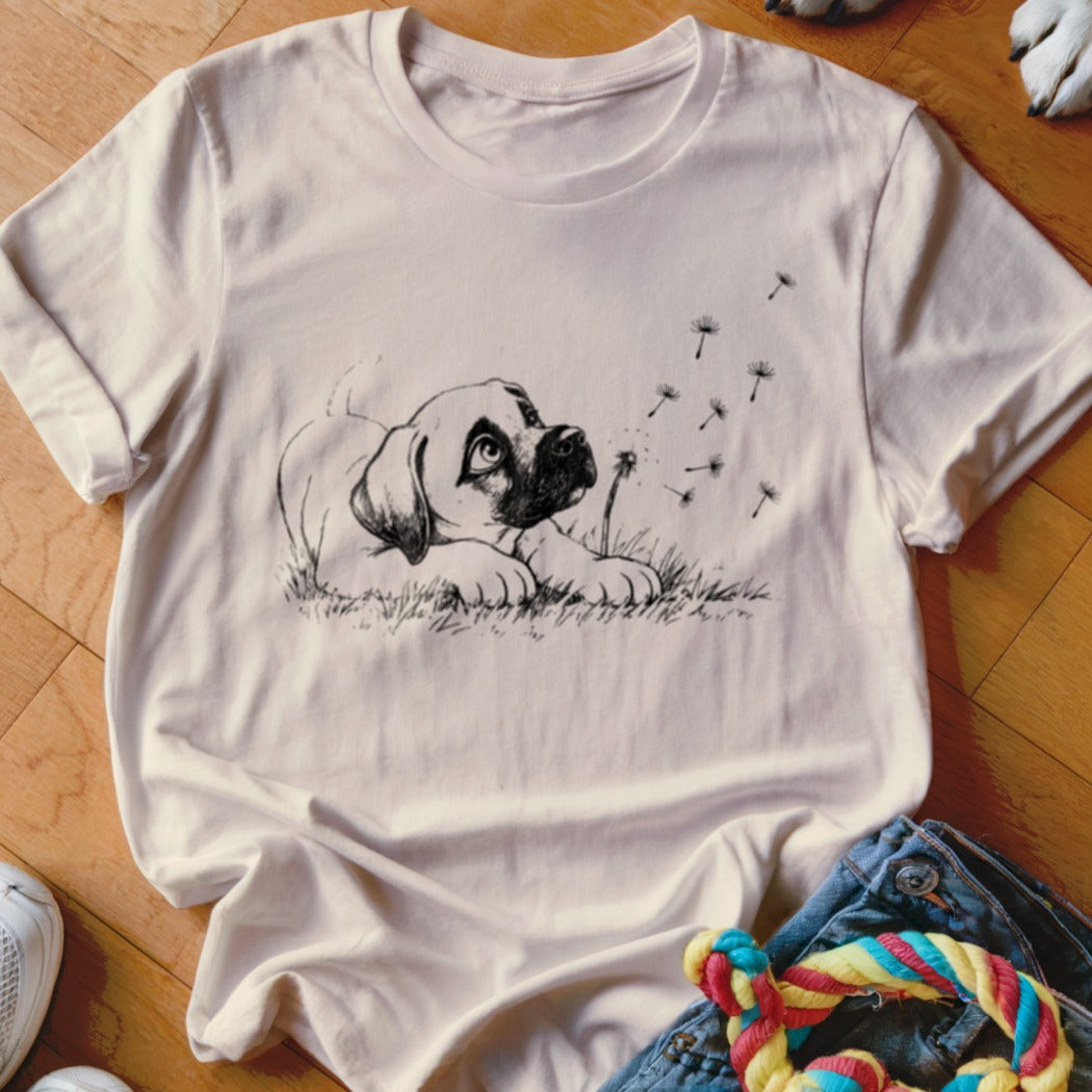 Light pink t-shirt featuring a black line drawing of a puppy looking up at dandelion seeds.