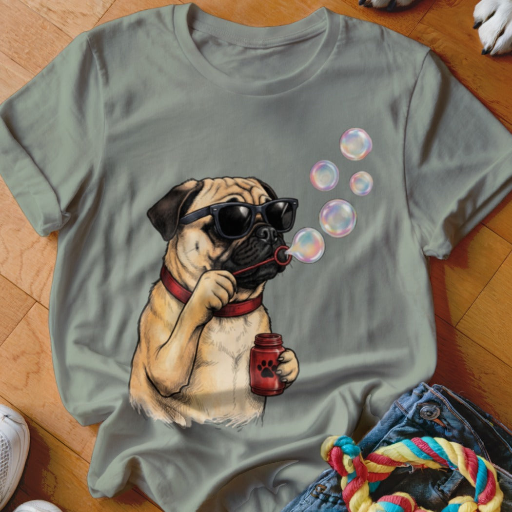 Sage green crewneck t-shirt featuring a graphic of a pug wearing sunglasses and blowing soap bubbles.