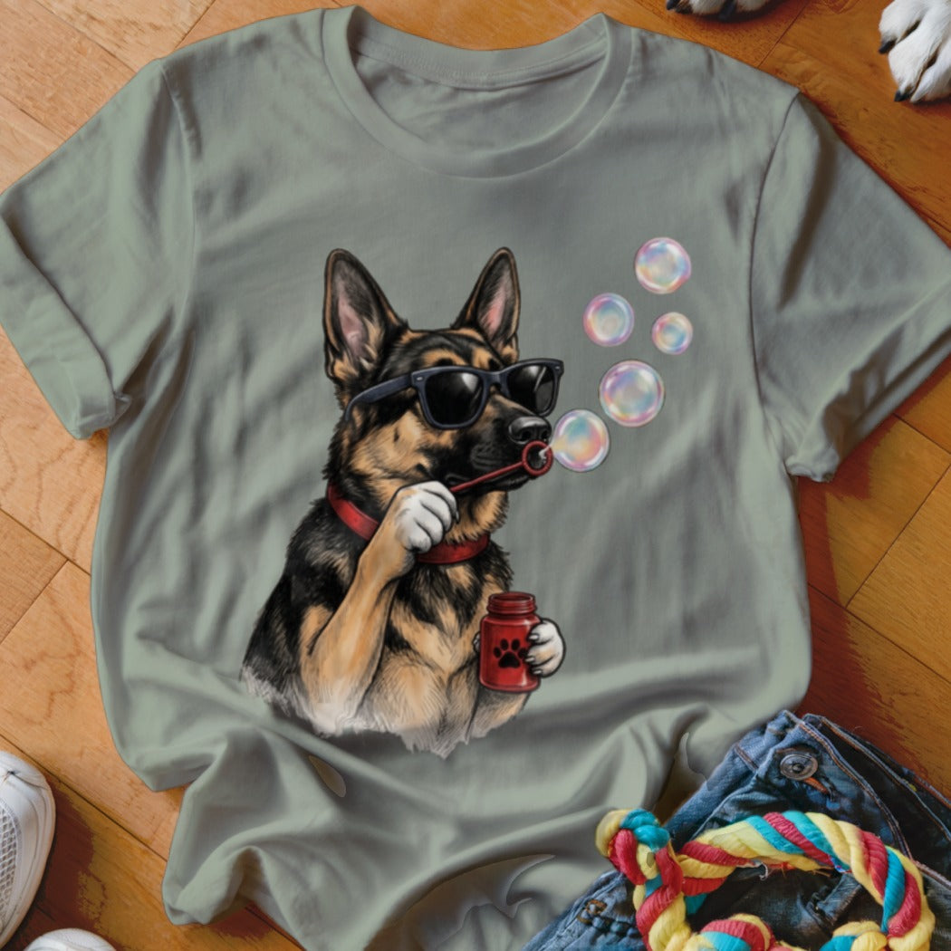 Sage green t-shirt featuring a graphic of a German Shepherd wearing sunglasses and blowing bubbles.