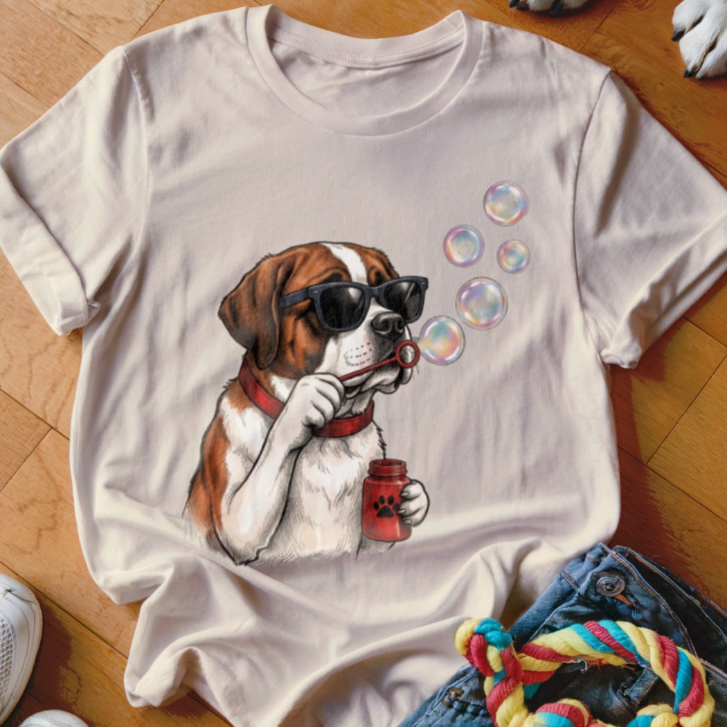 A cream t-shirt featuring an illustration of a Saint Bernard dog blowing bubbles while wearing sunglasses.