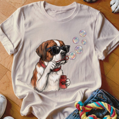 A cream t-shirt featuring an illustration of a Saint Bernard dog blowing bubbles while wearing sunglasses.