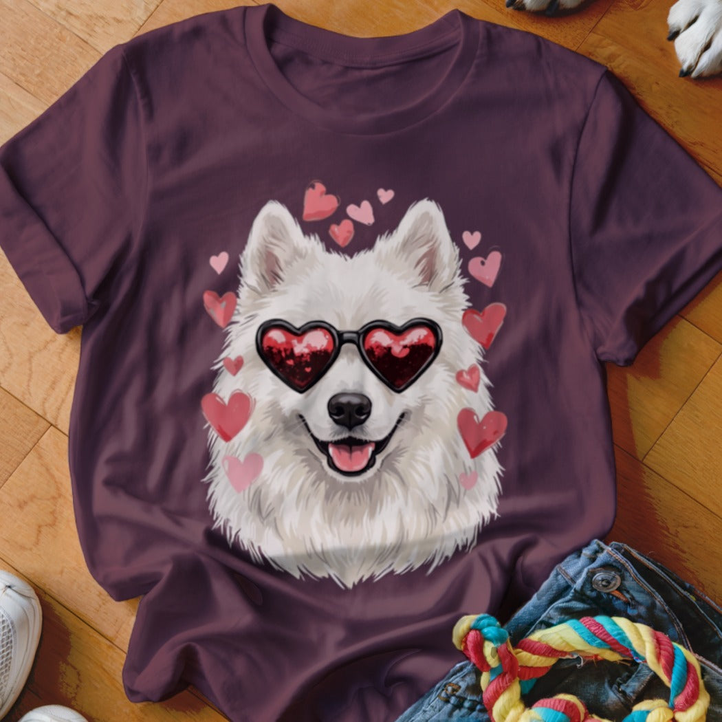 Maroon t-shirt featuring a graphic of a white Samoyed dog wearing heart-shaped sunglasses surrounded by pink hearts.