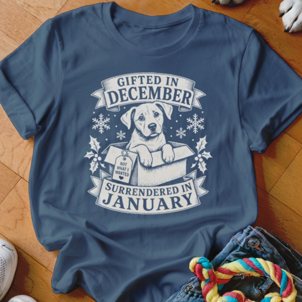 T-shirt with a puppy in a box and text "Gifted in December, Surrendered in January."