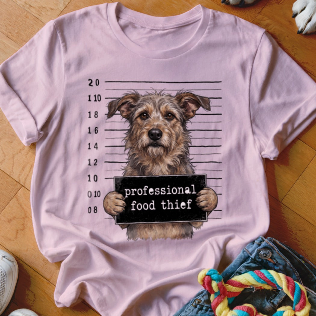 Pink t-shirt featuring a scruffy dog in a mugshot with "professional food thief" sign.