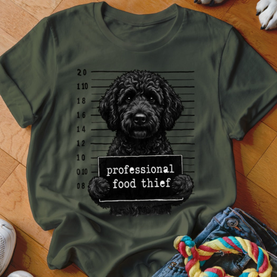 Black poodle mugshot with sign reading "professional food thief."