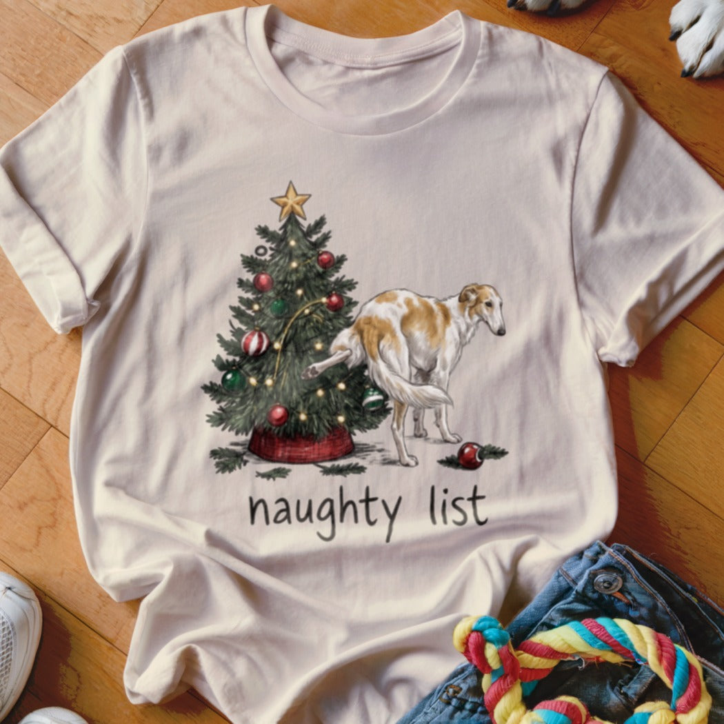 Cream t-shirt with a vintage graphic of a dog lifting its leg on a Christmas tree and the text "naughty list".