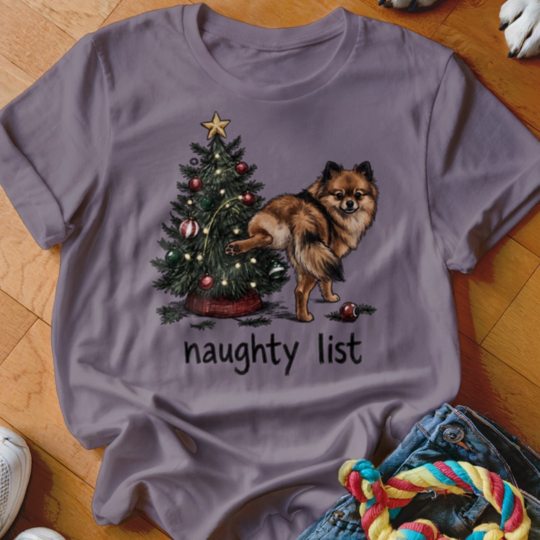 Pomeranian dog near Christmas tree with "naughty list" text.