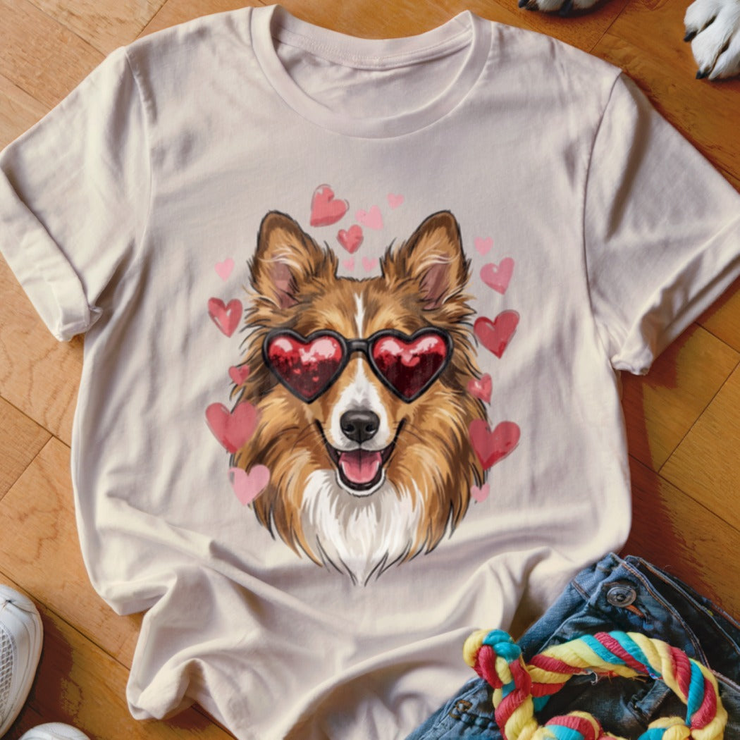 Beige t-shirt featuring a brown and white dog wearing heart-shaped sunglasses surrounded by pink hearts.