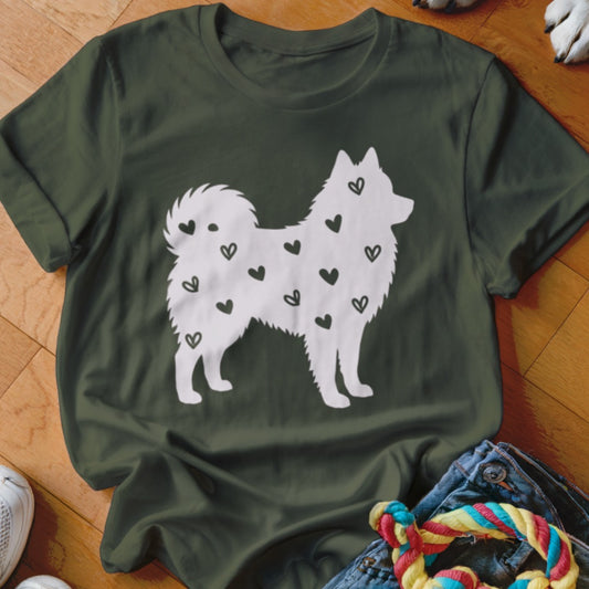 White silhouette of a fluffy dog with black hearts on a dark green t-shirt.