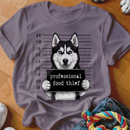Husky in mugshot holding a sign that says "professional food thief."