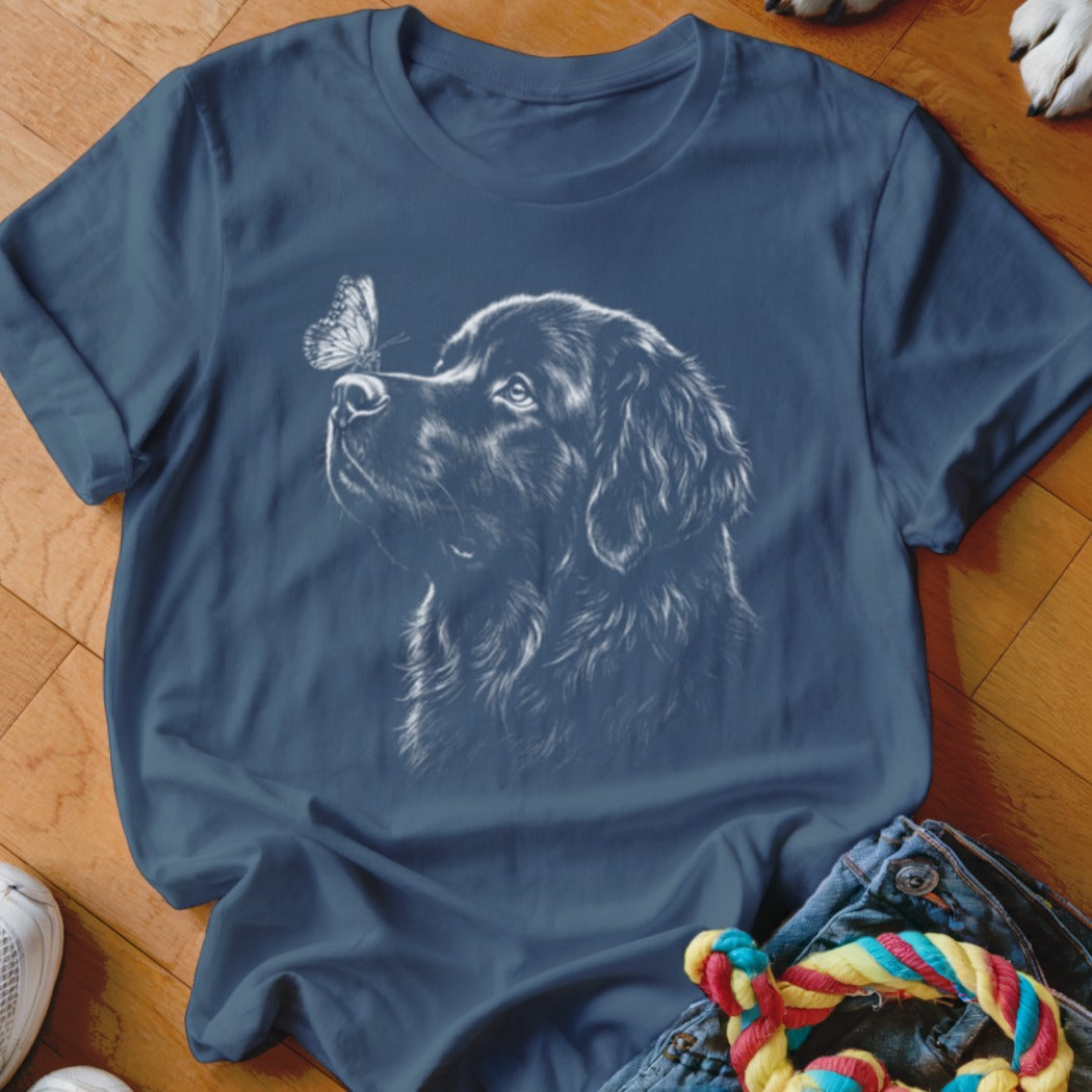 A blue crewneck t-shirt featuring a white line drawing of a dog looking at a butterfly on its nose.