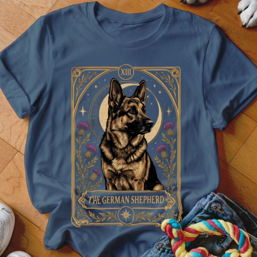 Blue t-shirt featuring a tarot card graphic of a German Shepherd with a crescent moon and thistles.