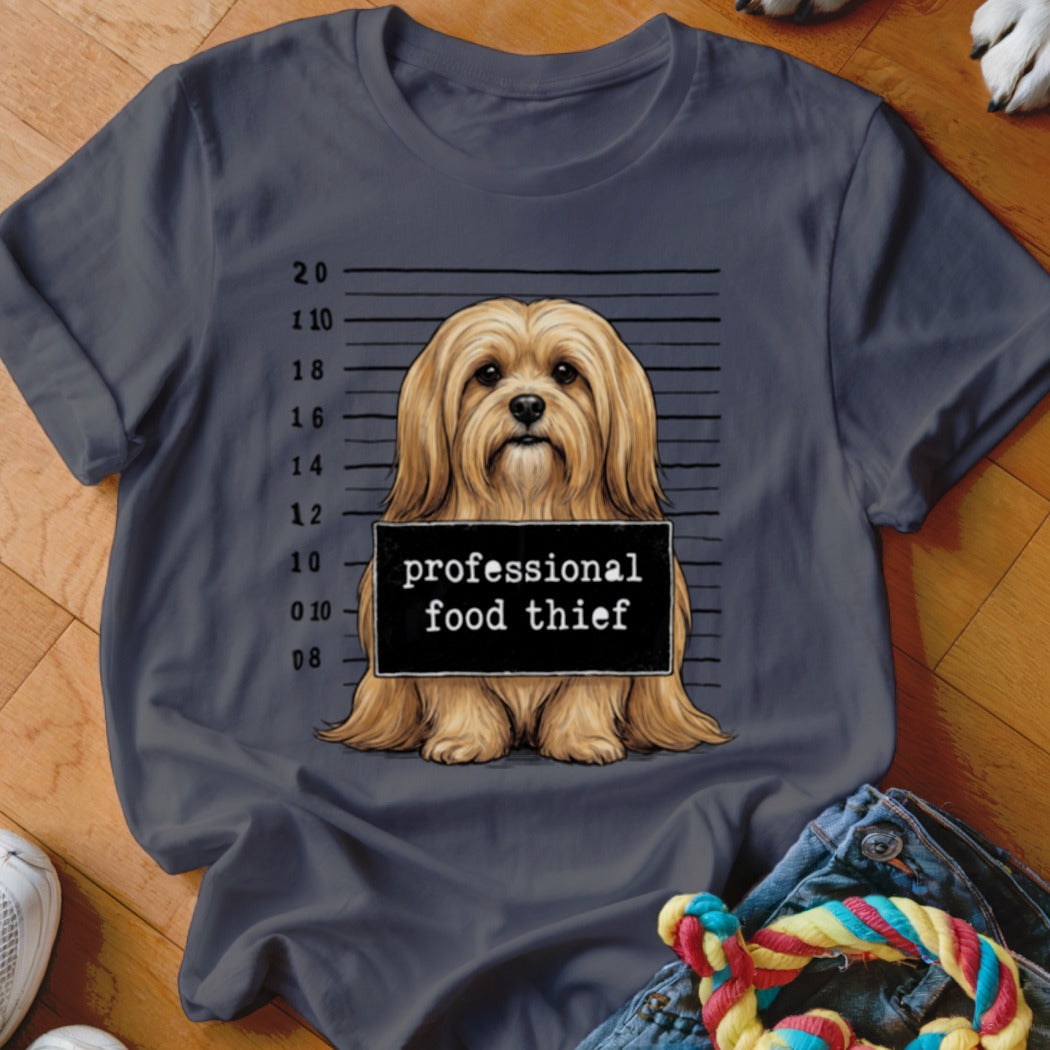 Dog mugshot with "professional food thief" sign.