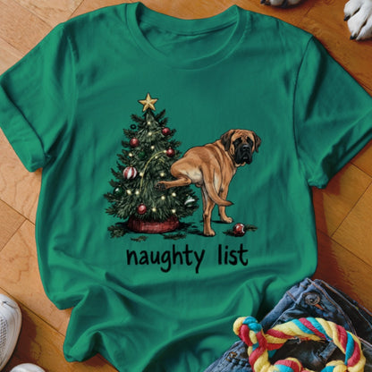 Green t-shirt with a dog lifting its leg on a Christmas tree with "naughty list" text.
