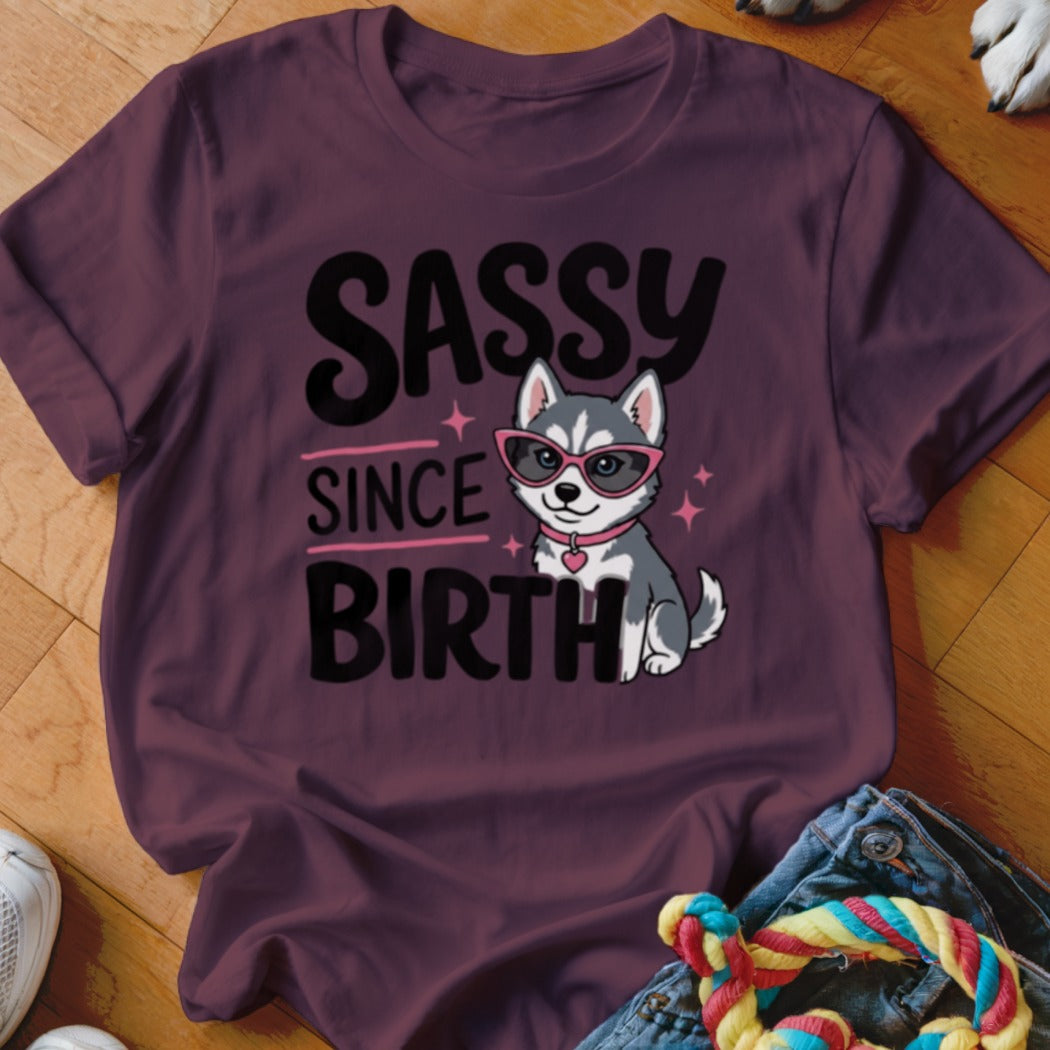 Burgundy t-shirt with cartoon husky wearing pink sunglasses and text "SASSY SINCE BIRTH".