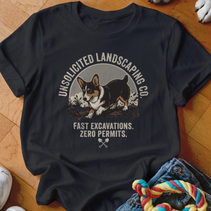Dark t-shirt with a Corgi digging and text "Unsolicited Landscaping Co. Fast Excavations. Zero Permits."