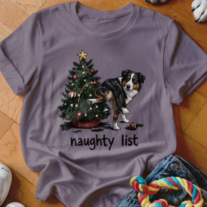 Australian Shepherd near Christmas tree with "naughty list" text.