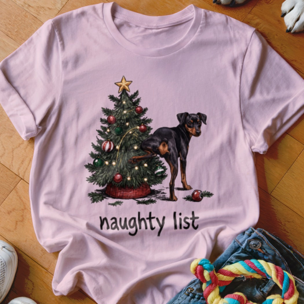 Pink t-shirt with a Christmas tree and a dog raising its leg, reading "naughty list".