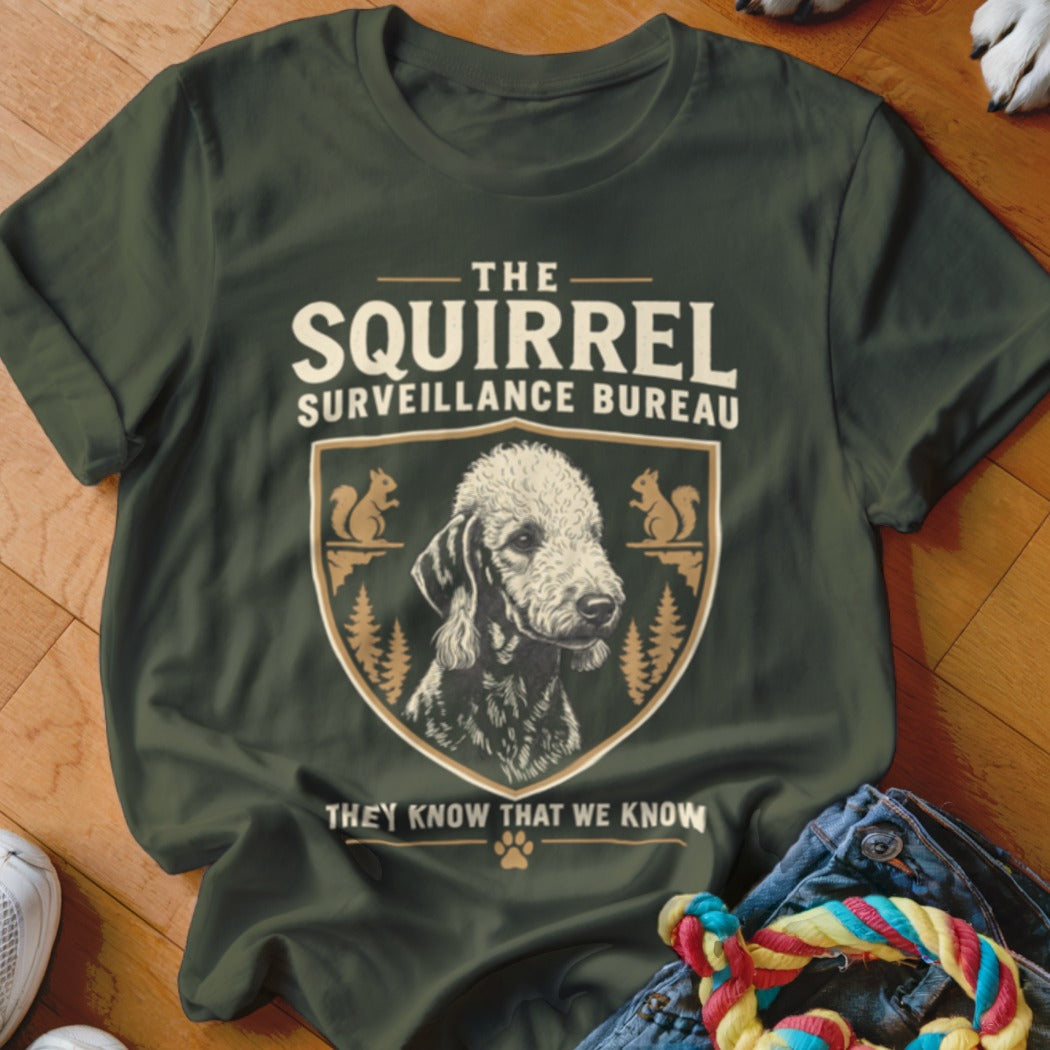 Dark green t-shirt with a vintage graphic featuring a dog, squirrels, and text reading The Squirrel Surveillance Bureau.