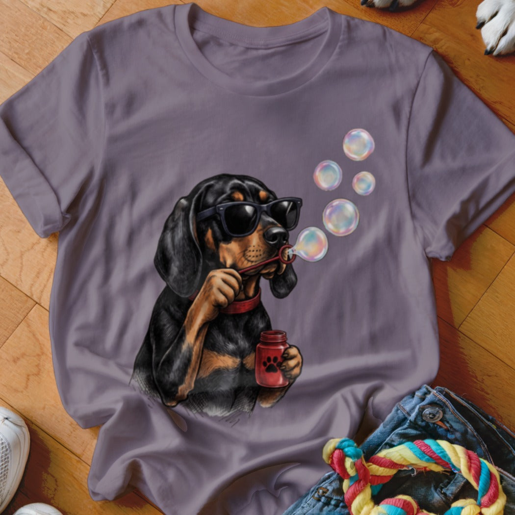 A purple t-shirt featuring a graphic of a black dog wearing sunglasses blowing bubbles.