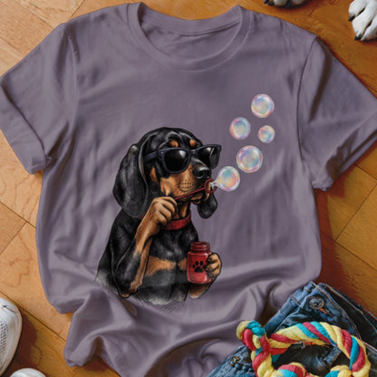A purple t-shirt featuring a graphic of a black dog wearing sunglasses blowing bubbles.