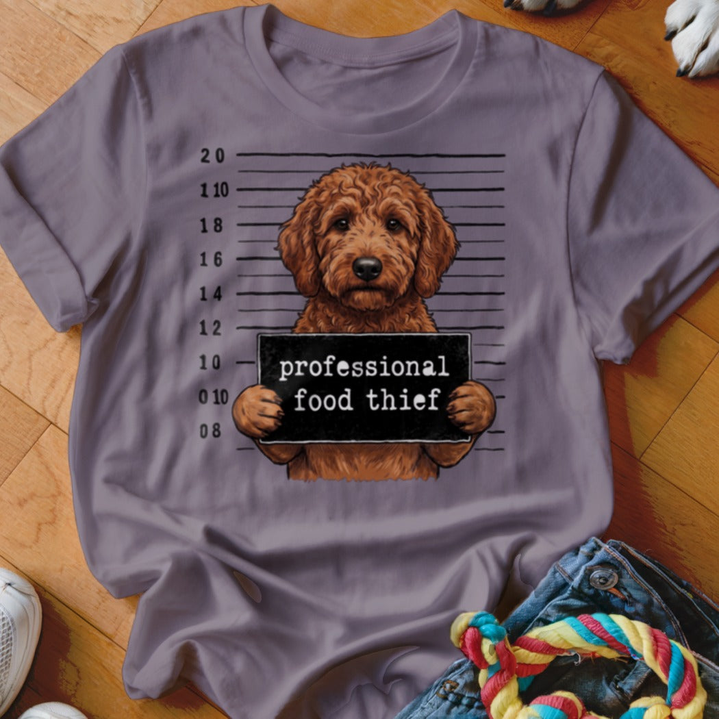 Brown dog with a "professional food thief" sign in a mugshot lineup.