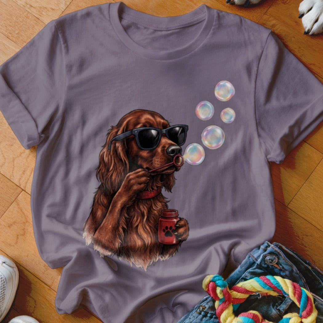 A purple t-shirt featuring an illustration of an Irish Setter wearing sunglasses and blowing soap bubbles.