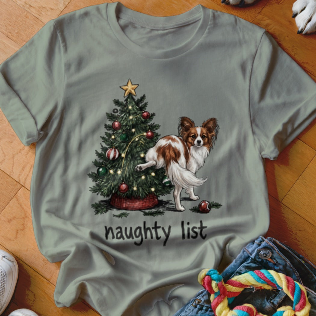 Papillon dog peeing on a Christmas tree with "naughty list" text.