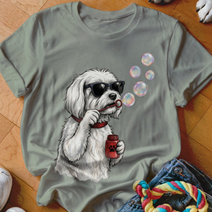 Sage green t-shirt featuring an illustration of a white dog wearing sunglasses and blowing bubbles.