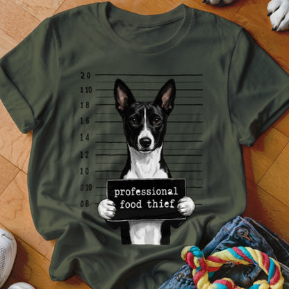 Basenji dog mugshot with "professional food thief" sign.