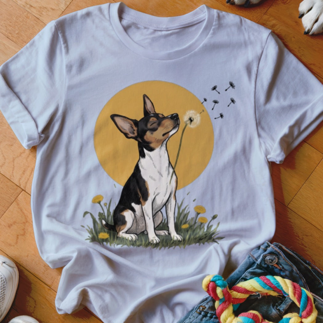 A white t-shirt featuring an illustration of a dog blowing dandelion seeds against a yellow circle background.