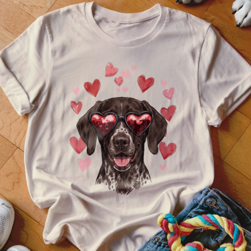 Cream t-shirt featuring an illustrated brown dog wearing heart-shaped sunglasses, surrounded by pink hearts.