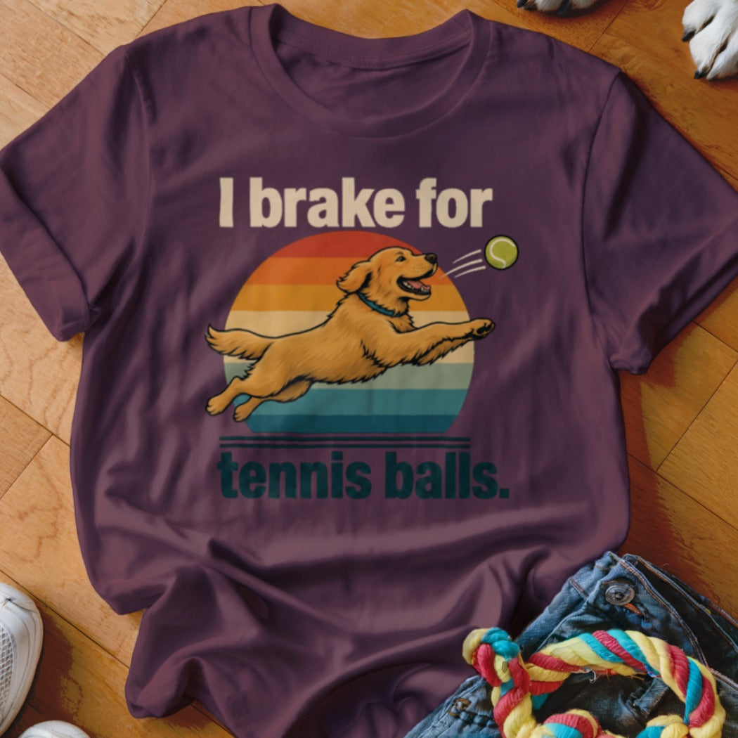 Golden retriever jumping for a tennis ball with "I brake for tennis balls" text.