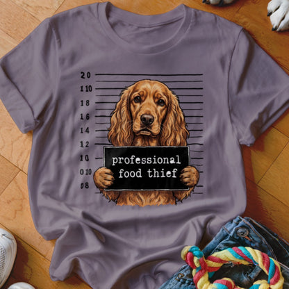 Cocker spaniel dog mugshot with "professional food thief" sign.