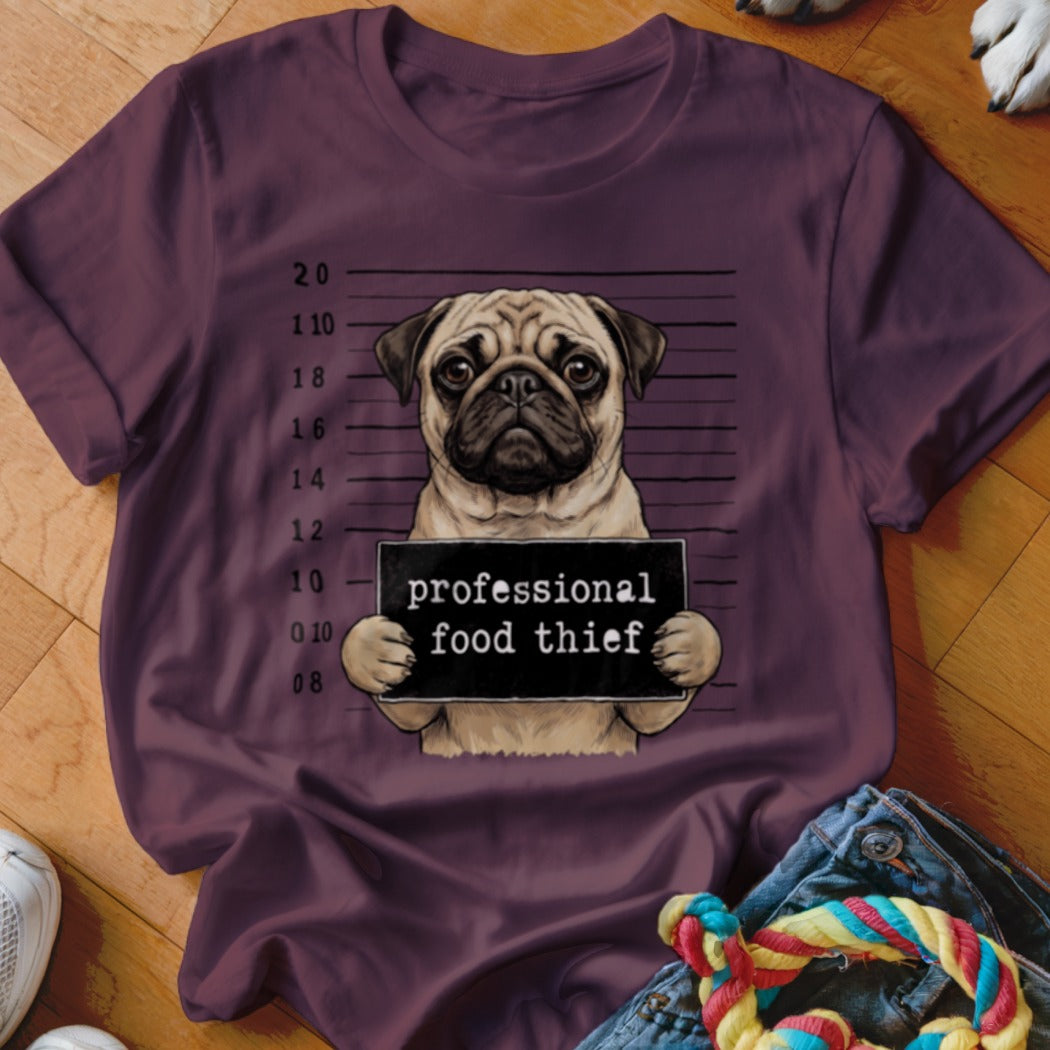 Pug in mugshot holding sign that says "professional food thief".